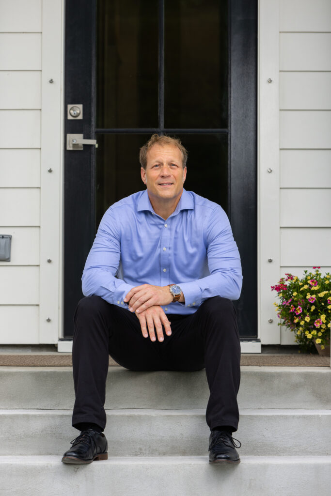 JP Boulden, counsellor, sitting on the steps of Professional Counselling Associates of Port Royal.